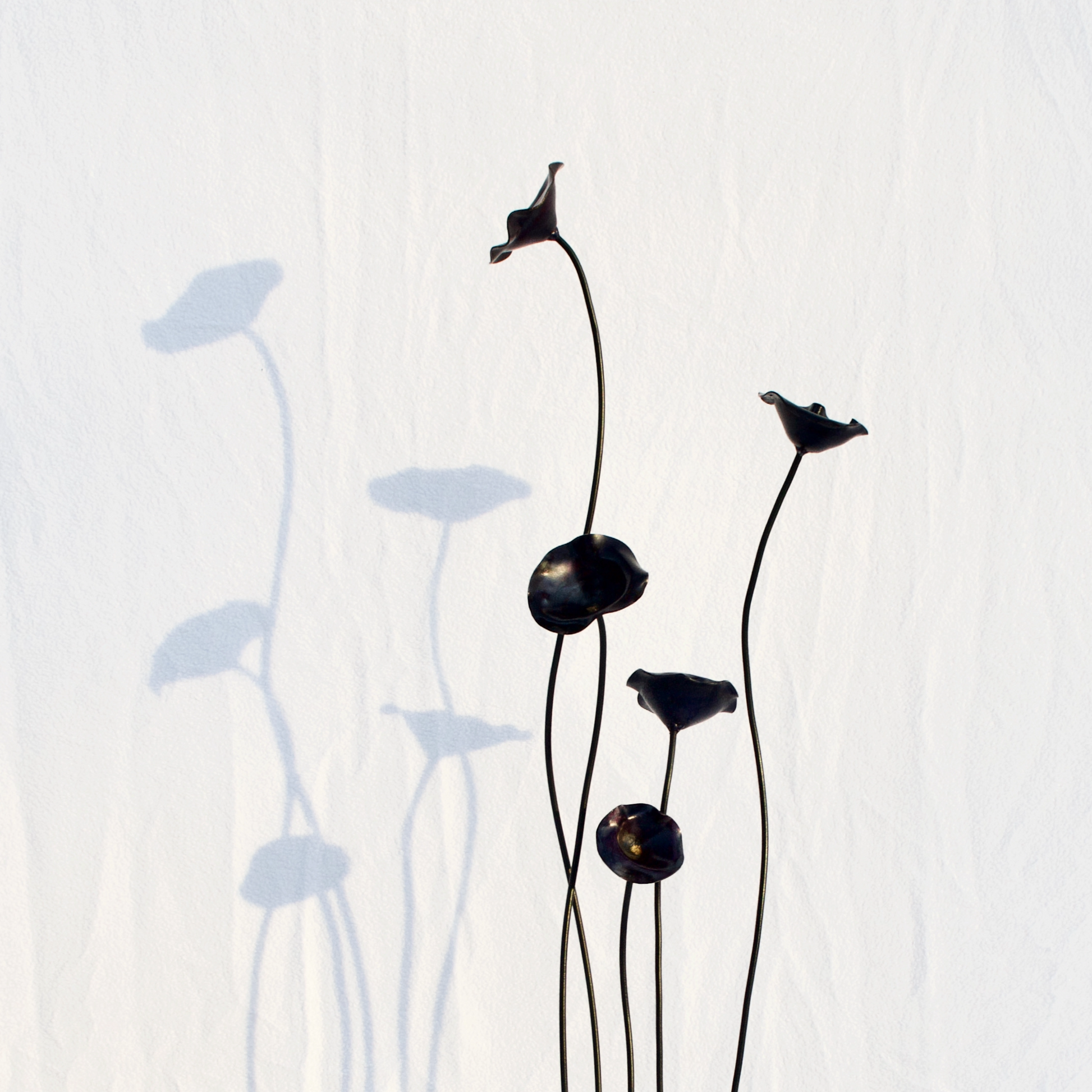 Large Steel Forged Poppy Sculpture. The flowers are violet with gold center.